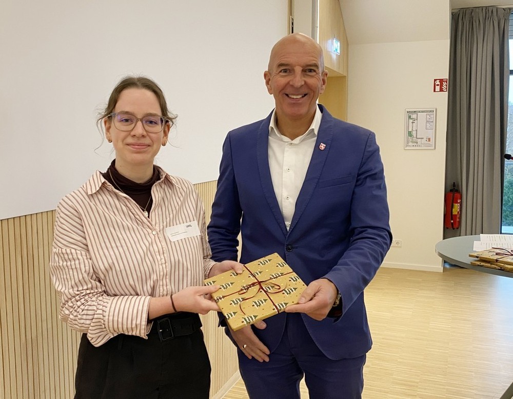 LWL-Landesdirektor Dr. Georg Lunemann überreicht einer Auszubildenden ein Geschenk.