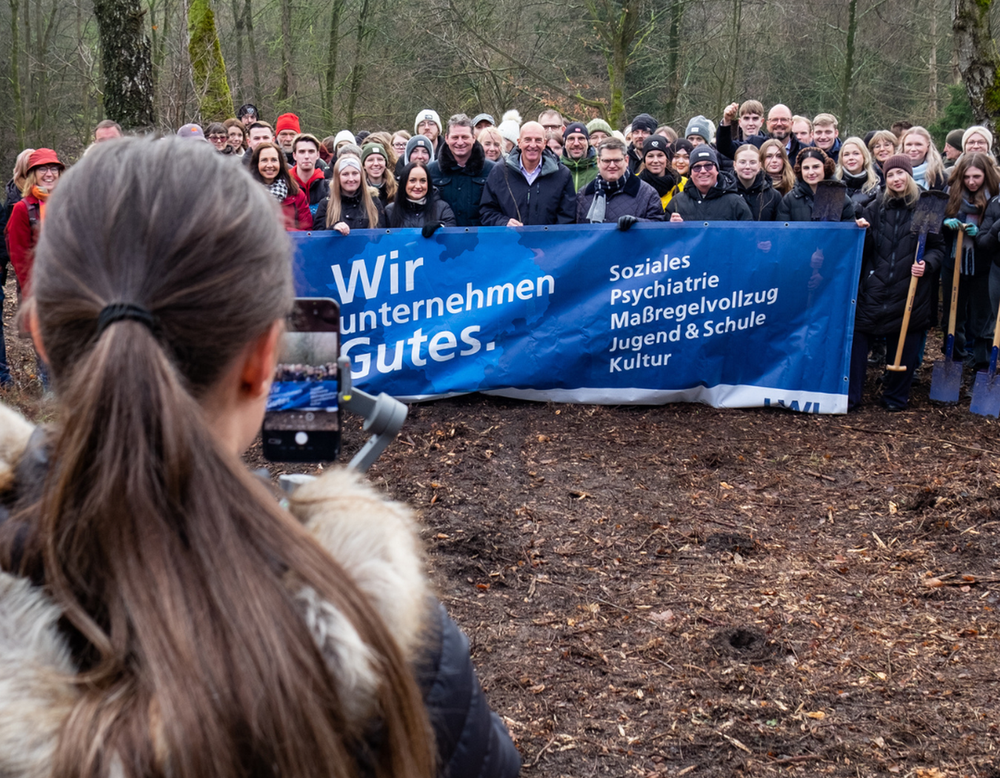 Gruppenfoto von Auszubildenden während der Baumpflanzaktion