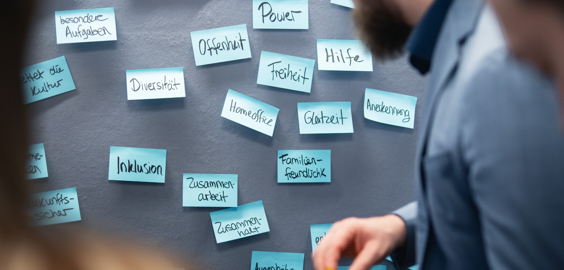 Person schaut auf Flipchart mit Post-its.